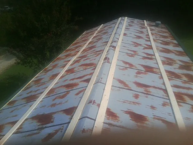 Rusted metal roof panels with new wood purlins before replacement — Storm Damage Roof Repair in Mattapoisett by Roofing Brothers