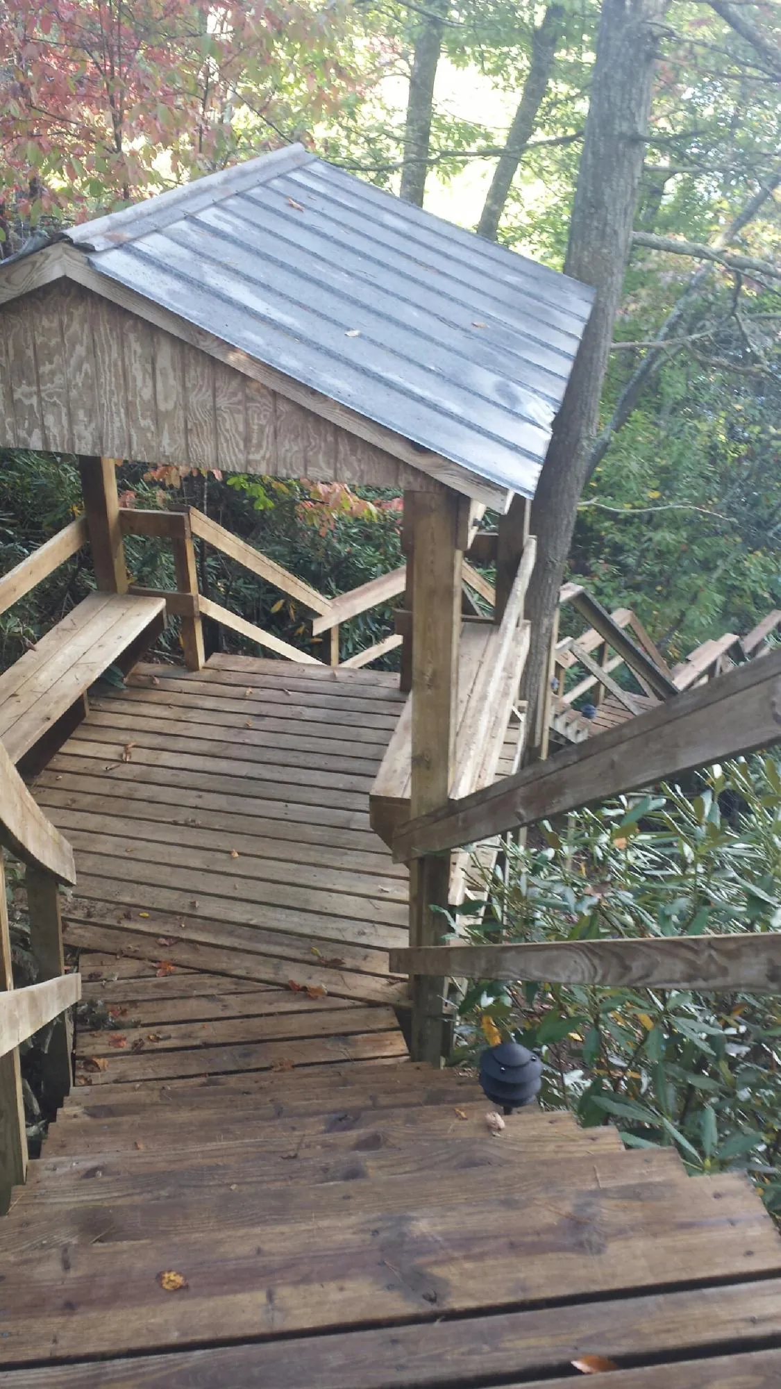 Metal roofed shelter over wooden steps on a wooded walkway — Skylight Repair & Installation work by our crew in Mattapoisett